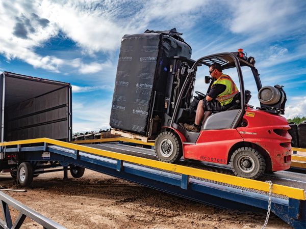 Image of an operator moving a bale of peat moss onto a truck.